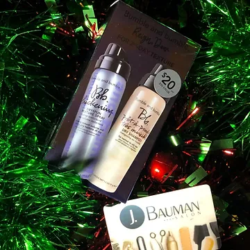 Two bottles of bb hair alchemist products displayed on a festive background of green tinsel and red lights, with a salon gift card labeled "$20" in view.