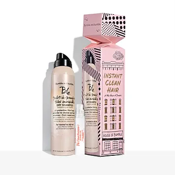 Bumble and bumble dry shampoo spray beside its pink and black patterned packaging box, labelled "instant clean hair" with graphical illustrations.