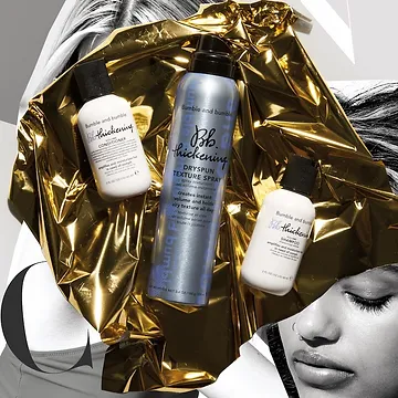 A promotional image featuring three bumble and bumble hair products on a crumpled gold foil background, with a partial view of a woman's face with closed eyes, emphasizing relaxation and luxury.