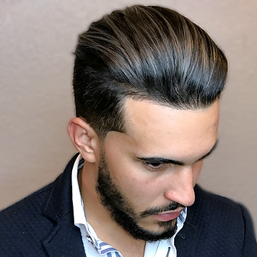 A man with a styled, voluminous undercut hairstyle, featuring short sides and a longer, slicked-back top, in a professional attire with a navy blazer and striped shirt.